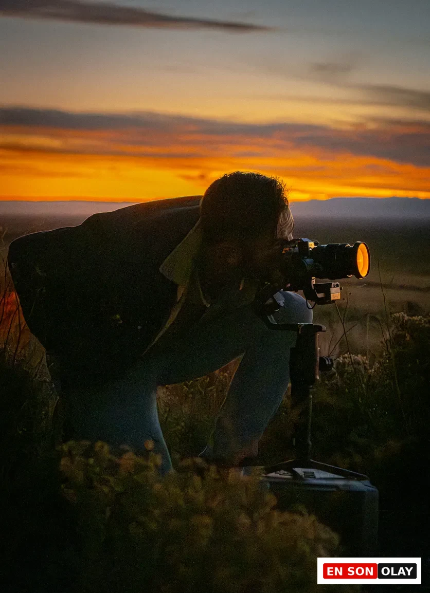 Gün batımında tripod üzerinde analog fotoğraf makinesiyle çekim yapan kişi