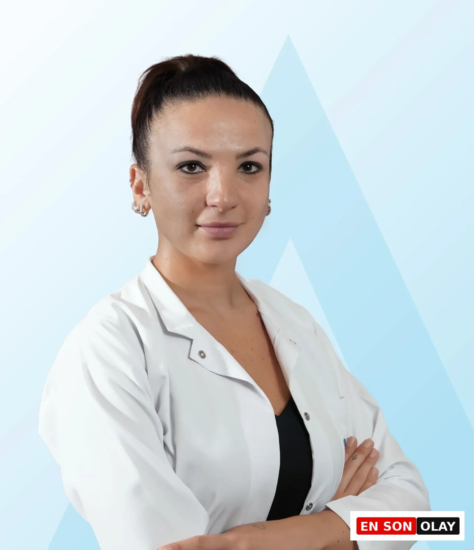 Beyaz önlüklü Doktor Sena Sivri, kollarını kavuşturmuş ve hafifçe gülümseyerek doğrudan kameraya bakarken, mevsimsel duygu durum bozukluğu ile mücadelede aromaterapinin biyokimyasal dengeyi sağlamadaki rolünü anlatan yazıda okuyuculara rehberlik ediyor.