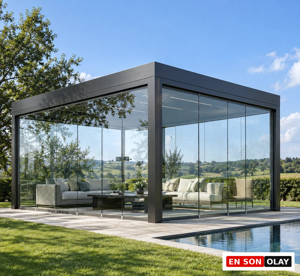 Müstakil bir bahçede bulunan, siyah çerçeveli, şeffaf cam duvarlara sahip bu modern minimalist cam oda tasarımı, içindeki konforlu oturma grupları ve hemen yanındaki yüzme havuzuyla yemyeşil kırsal manzarayı net bir şekilde sunarak şık ve ferah bir yaşam alanı vadediyor.