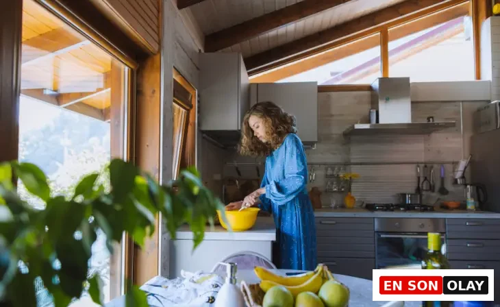 Ahşap çatılı mutfakta meyve ve zeytinyağları eşliğinde yemek hazırlayan kadın