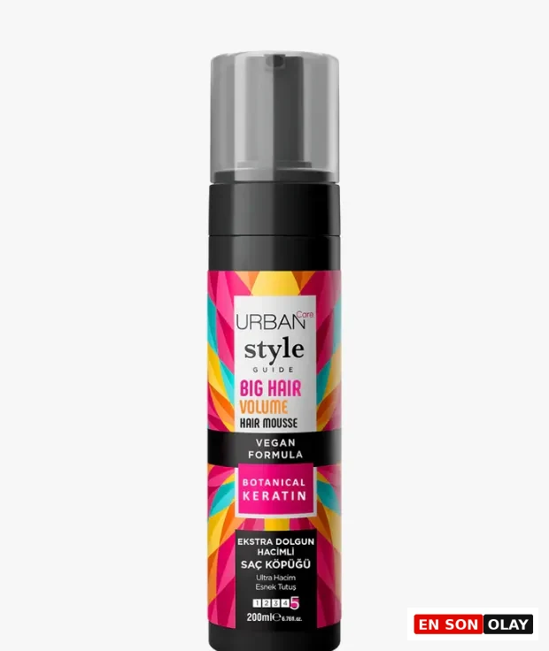 Beyaz bir arka plan üzerinde dik duran, siyah gövdeli ve şeffaf pompalı kapağı olan Urban Care Style Guide Big Hair Volume saç köpüğü şişesi; canlı, geometrik desenli etiketiyle saçlara ekstra hacim ve dolgunluk veren bir ürün olduğunu vurguluyor.