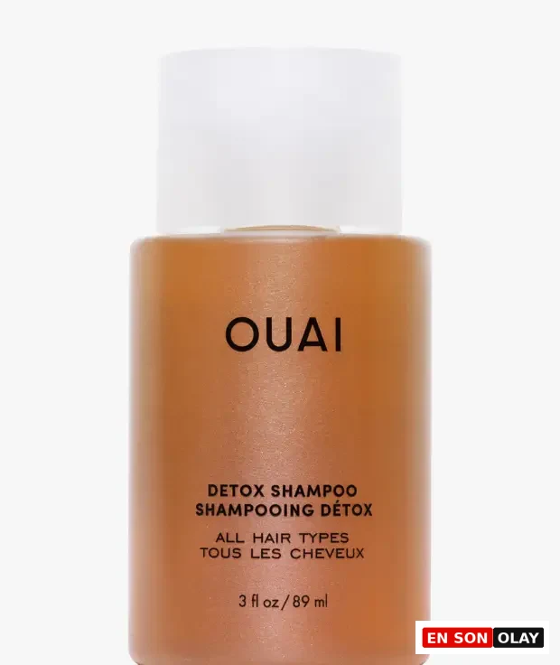 Beyaz arka plan üzerinde konumlanmış, beyaz kapaklı, parlak karamel rengi OUAI detoks şampuanı şişesi; ön yüzünde belirgin siyah harflerle DETOX SHAMPOO, ALL HAIR TYPES ve 89 ml / 3 fl oz bilgileriyle saç bakımı makalesi için ideal bir görsel sunuyor.