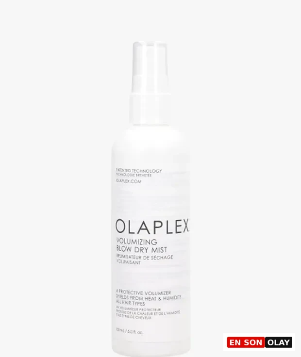 Beyaz arka plan önünde, üzerinde Olaplex markası ve Volumizing Blow Dry Mist yazan, saçlara hacim veren ve ısı ile neme karşı koruma sağlayan 150 ml'lik bir fön spreyi şişesi dik duruyor.