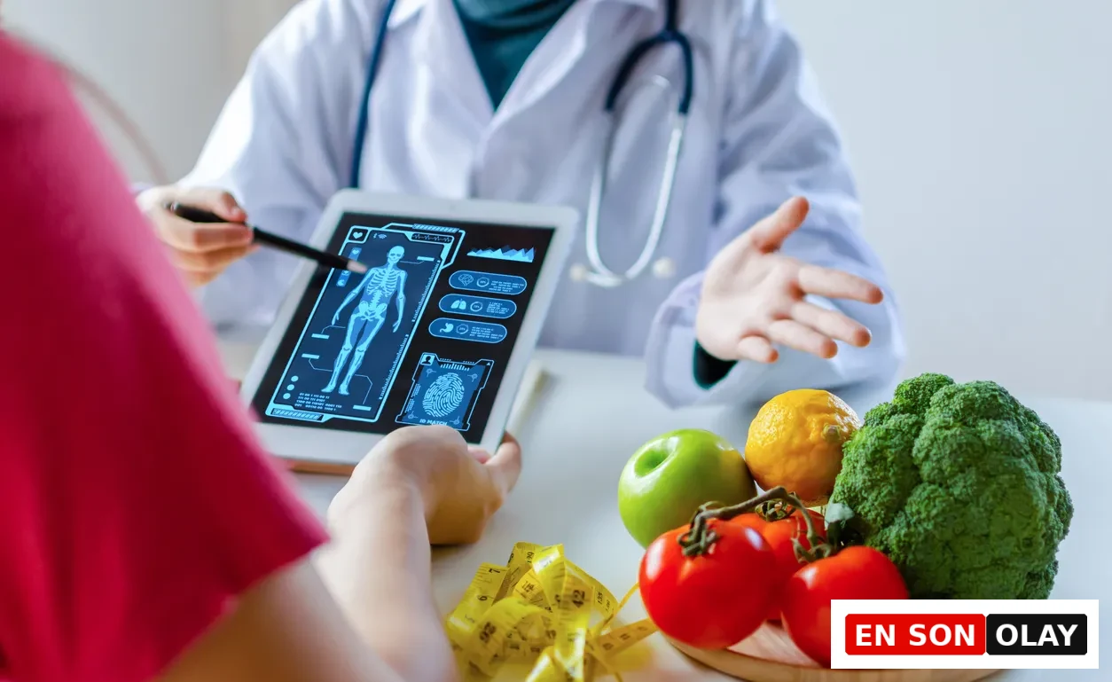 Beyaz önlüklü bir doktorun, masada duran yeşil elma, limon, domates, brokoli gibi taze sebze ve meyveler ile ölçüm bandının yanında, bir hastasına tablet ekranındaki iskelet ve organ gibi dijital sağlık verilerini detaylı bir şekilde açıklayarak kişiselleştirilmiş beslenme ve sağlık tavsiyeleri verdiği an.