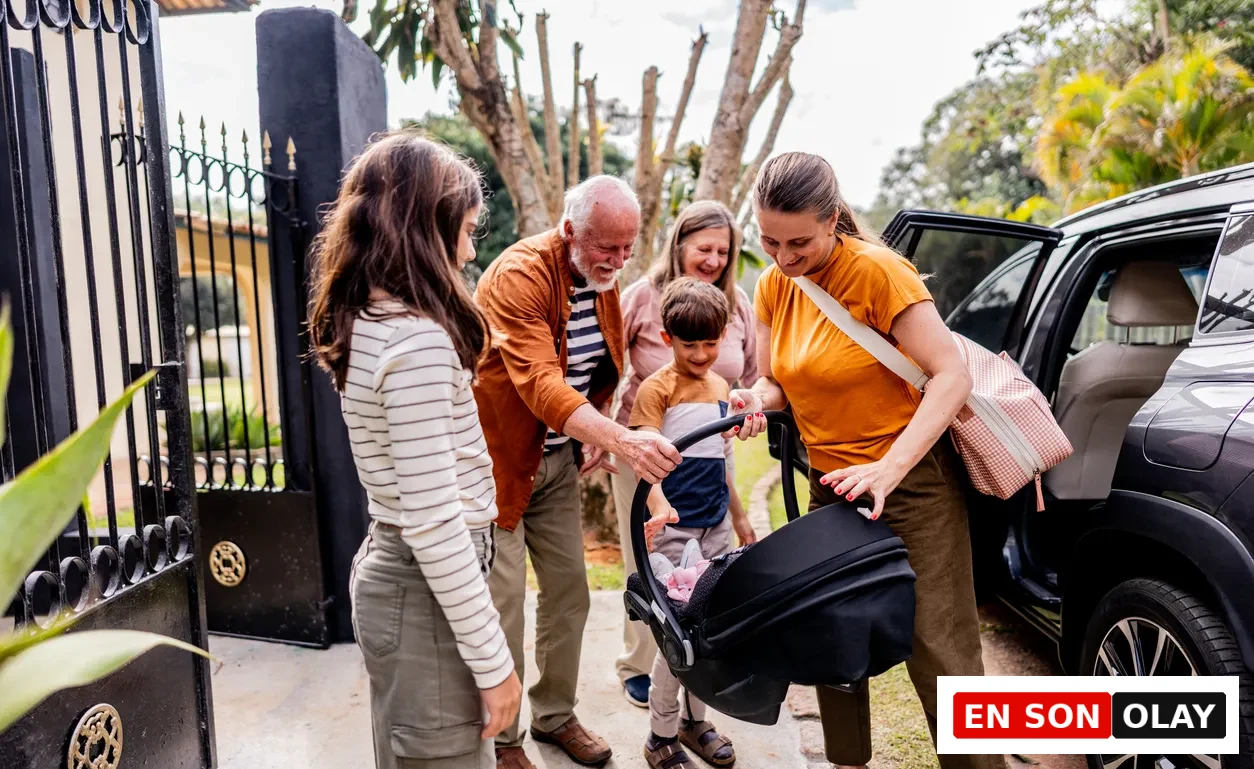 Aile üyeleri (büyükbaba, büyükanne, anne, baba ve iki çocuk), gülümseyerek arabadan bebek oto koltuğunu indirirken, bu an aile seyahati için yapılan tatlı hazırlıkları gözler önüne seriyor.