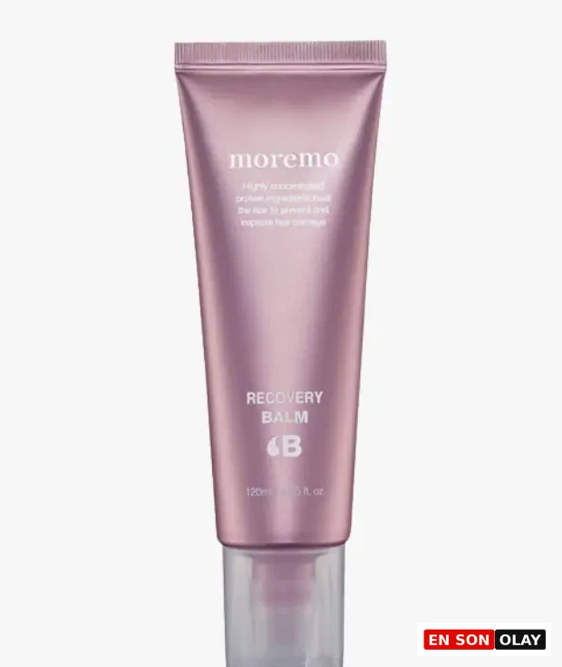 Görselde, üzerinde moremo markası ve RECOVERY BALM 6B yazısı bulunan, parlak pembe mor tonlarında, hasar görmüş saçları onarmaya ve ısıya karşı koruma sağlamaya yönelik 120 ml'lik şeffaf kapaklı bir saç kremi tüpü beyaz arka plan üzerinde dikey konumda duruyor.