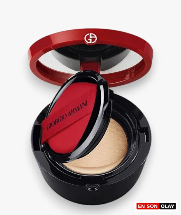 Açık kırmızı kapaklı siyah Giorgio Armani My Armani To Go cushion fondöten kabı, içinde açık bej rengi fondöten ve üzerinde markanın adı yazan kırmızı aplikatör süngeriyle beyaz bir arka planda özenle sergileniyor.