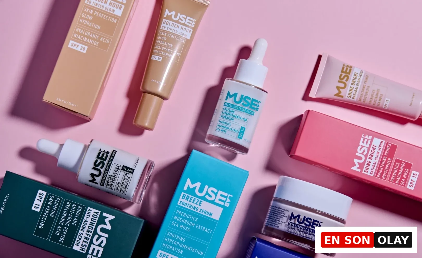 Pembe bir zemin üzerinde dağınıkça yerleştirilmiş Muse Lab cilt bakım ürünleri koleksiyonu, farklı renklerdeki kutu ve şişeleriyle dikkat çekiyor; SPF korumalı Golden Hour BB Tinted Glow, Breeze Soothing Serum ve Young & Fresh Anti-Aging Serum gibi çeşitli ürünler arasında, hyaluronik asit ve prebiyotik gibi aktif içerikler vurgulanıyor.