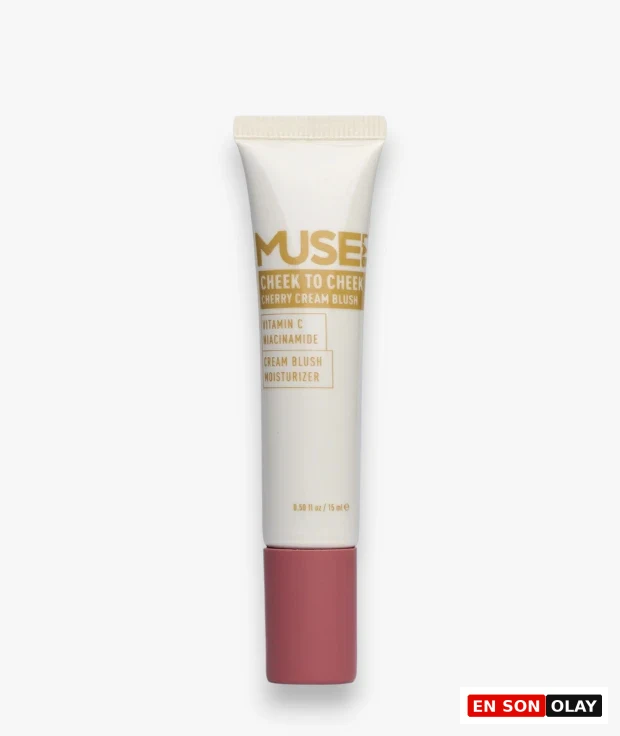 Beyaz arka plan üzerinde dikey duran, somon pembe kapağıyla dikkat çeken, üzerinde MUSE! CHEEK TO CHEEK CHERRY CREAM BLUSH ibaresi bulunan, C Vitamini ve Niasinamid içeren nemlendiricili bir krem allık tüpü detaylıca gösteriliyor.