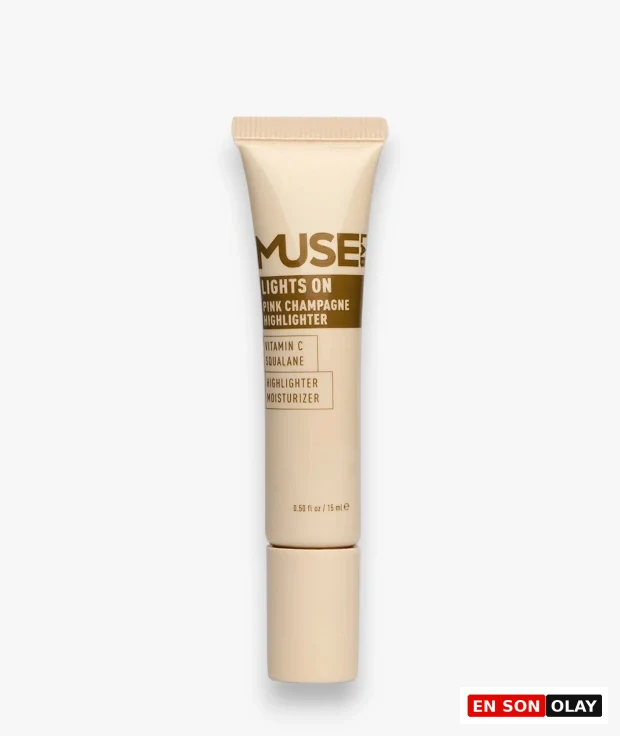 Aydınlık beyaz bir zemin üzerinde dikey duran, Muse Labs markasının Lights On Pink Champagne Highlighter adlı, C vitamini ve skualan içerikli pembe şampanya tonlarında, hem aydınlatıcı hem de nemlendirici özelliklere sahip kozmetik ürünü.