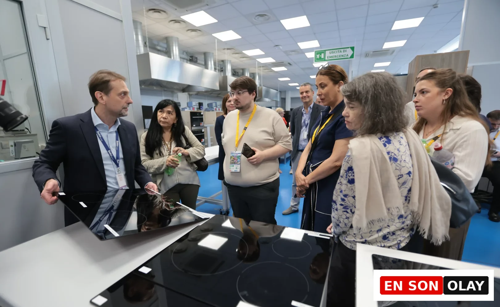 Beko Europe'un Kuzey İtalya'daki tasarım kalbi Cassinetta'da, bir teknoloji uzmanı, ziyaretçilere modern mutfakların geleceğini şekillendiren ankastre pişirici ürünlerin yeni teknoloji ve tasarım detaylarını yansıtan parlak siyah cam yüzeyleri tanıtırken, grubun ürün geliştirme ve inovasyon süreçlerine ışık tutuyor.