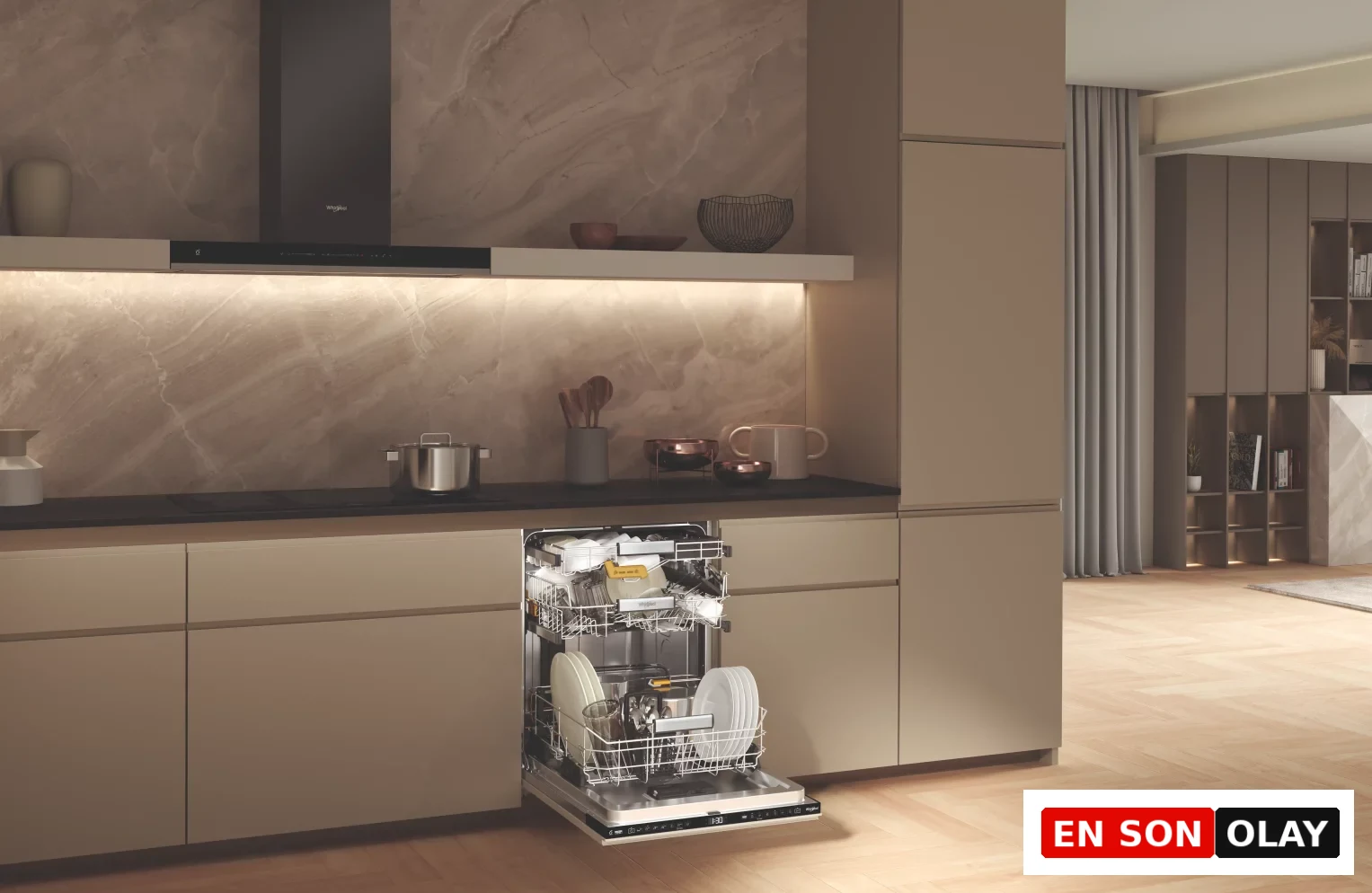Modern ve premium bir mutfak ortamında, açık kapaklı ve içi ışıklı Whirlpool bulaşık makinesi, şık ankastre tasarımını, lüks algısını ve yapay zeka ile entegre mutfak teknolojilerini vurgulayarak evin merkezindeki rolünü sergiliyor.