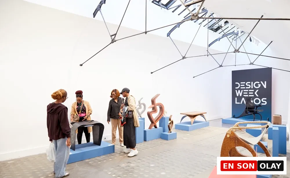 Geniş ve aydınlık bir galeride, Lagos Tasarım Haftası sergisi kapsamında sunulan, farklı tasarımlara sahip modern mobilya parçaları ve soyut heykelsi objeler mavi podyumlar üzerinde sergilenirken, ziyaretçiler bu özgün ve yenilikçi eserleri dikkatle inceliyorlar.
