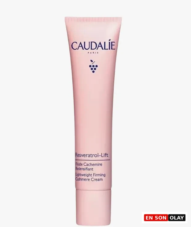 Açık pembe renkteki Caudalie Resveratrol-Lift Lightweight Firming Cashmere Cream tüpü, üzerinde markanın üzüm sembolüyle, Resveratrolün cilt yaşlanmasını hücresel düzeyde durdurma ve longevity faydalarına vurgu yapan yazıyla dikkat çekiyor.