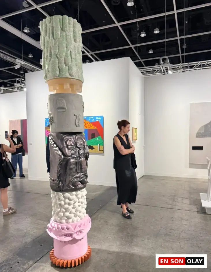 Çeşitli yüzey dokularına sahip katmanlı totem heykel, Art Basel’de kültürel motifler ve çağdaş heykel dili arasında dikkat çekici bir geçiş kuruyor.