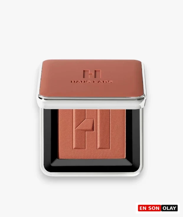 Yarı açık kapağıyla beyaz zeminde duran, metalik gümüş kenarlıklı ve turuncu-kahve tonlarındaki Haus Labs Color Fuse Blush Fire Moon allık paleti, hem kapağında hem de allığın yüzeyinde markanın kabartmalı H logosunu sergiliyor.
