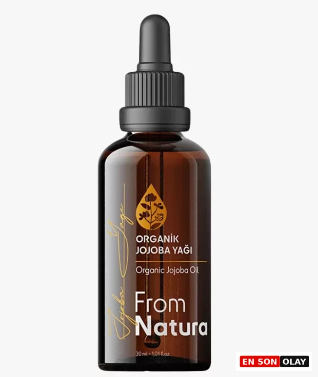 Beyaz bir zeminde duran, kehribar rengi camdan yapılmış, siyah damlalık kapaklı ve üzerinde ORGANİK JOJOBA YAĞI ibaresi bulunan etiketiyle soğuk sıkım kalitesini yansıtan 30 ml'lik From Natura marka Jojoba Yağı şişesi, posttaki cilt bariyeri onarımı ve mucizevi faydalarına uygun olarak vurgulanıyor.