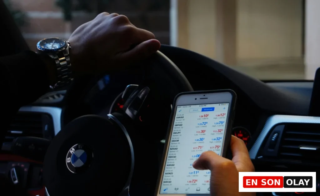 Bir sürücü, BMW aracının içinde döviz ve yatırım piyasalarını mobil uygulama üzerinden anlık olarak takip ediyor.