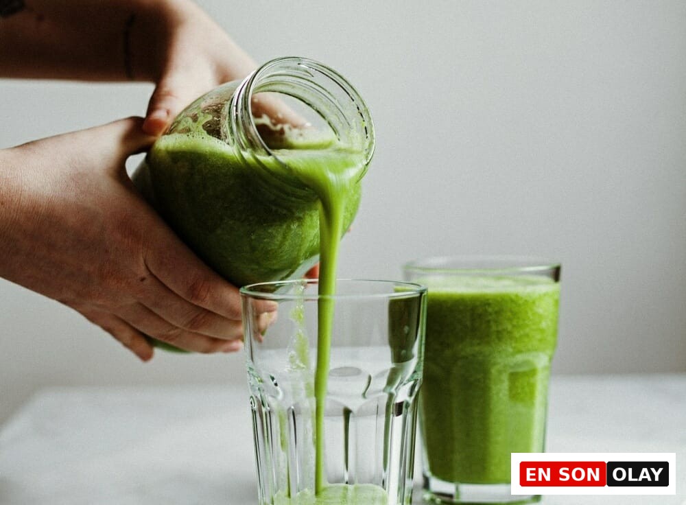 Kavanozdan bardağa dökülen taze hazırlanmış yeşil smoothie, sağlıklı yaşam ve detoks için doğal bir içecek.