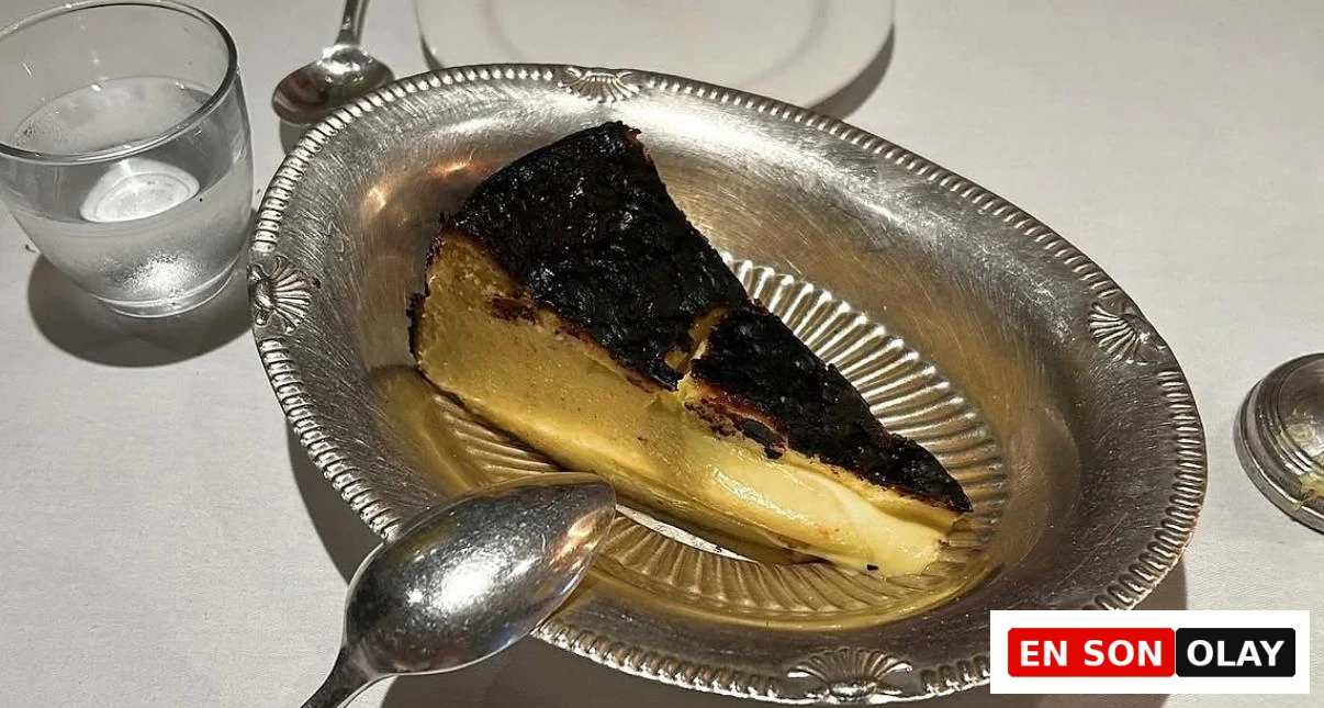Kremamsı dokusu ve davetkar görünümüyle dikkat çeken, pürüzsüz yüzeyi ve hafifçe kızarmış kenarlarıyla beyaz bir tabakta sunulan klasik bir cheesecake dilimi, tatlı severler için vazgeçilmez bir lezzet deneyimi sunuyor.